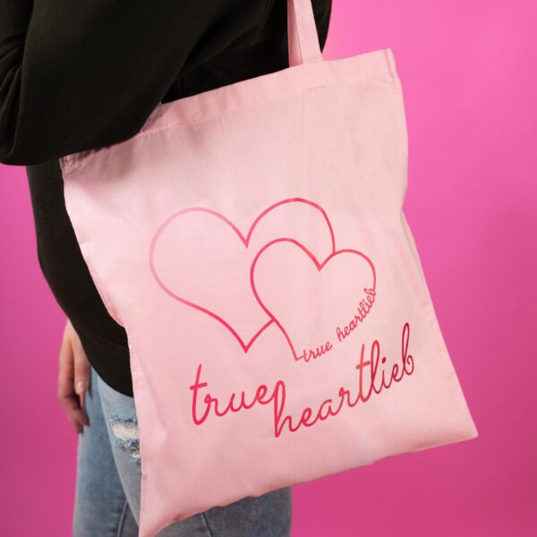 Frau trägt Trueheartlieb Tasche mit "Trueheartlieb" Motiv in Pink