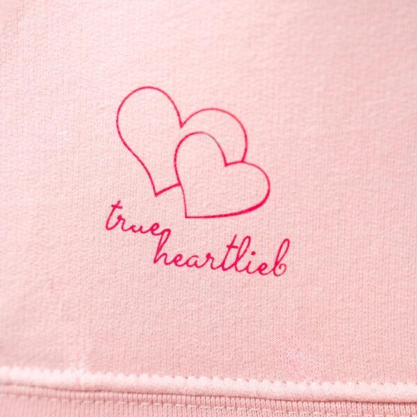 Trueheartlieb-Logo Nahaufnahme auf Rosa Stoff
