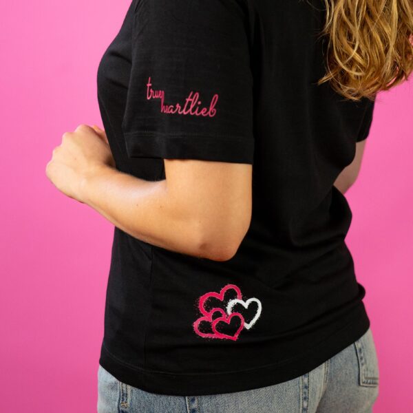 Eine Frau, die die Rückseite des getragenen Trueheartlieb-T-Shirt zeigt