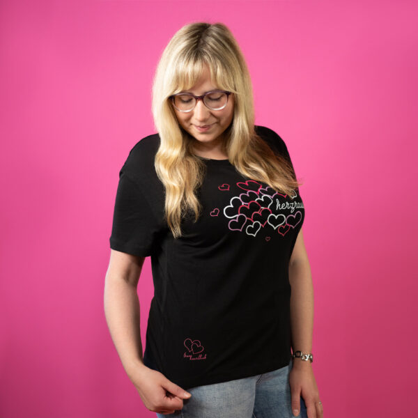 Blonde Frau im schwarzen Trueheartlieb-T-Shirt mit Herzrausch motiv