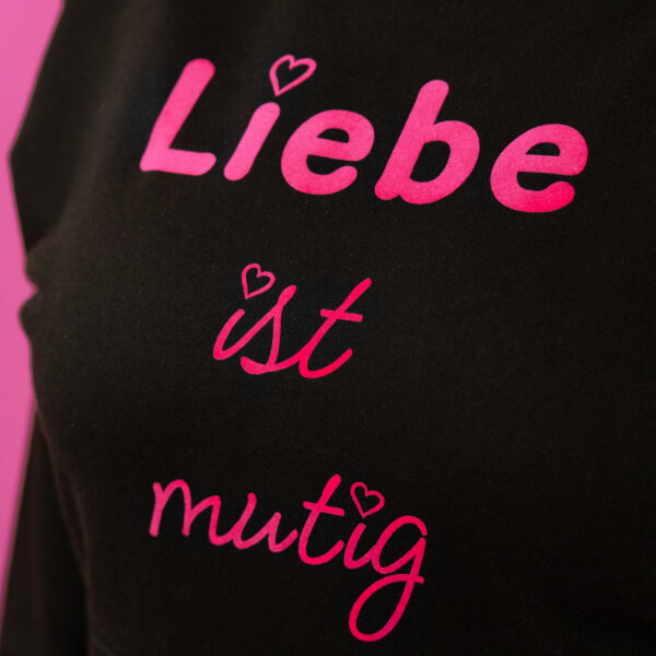 Nahaufnahme Schwarzer Trueheartlieb-Hoodie mit „Liebe ist mutig“