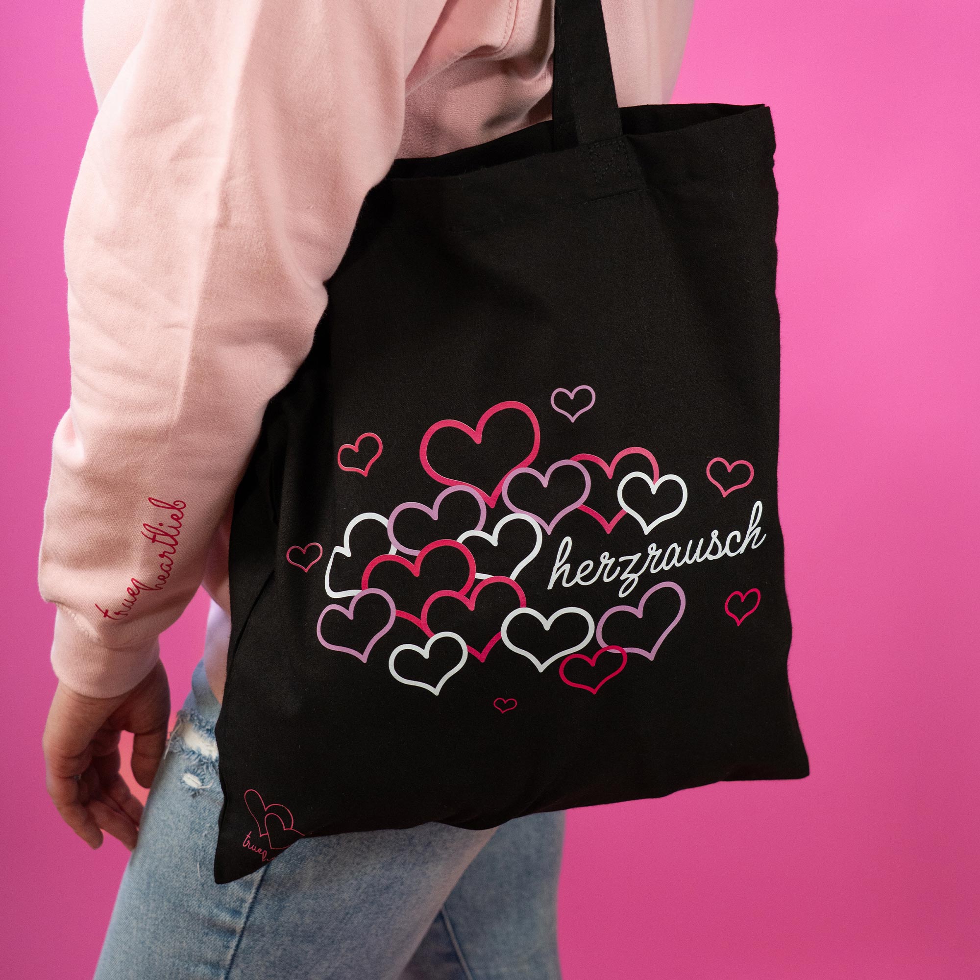 Frau trägt eine Trueheartlieb Tasche in Schwarz mit "Herzrausch" Motiv