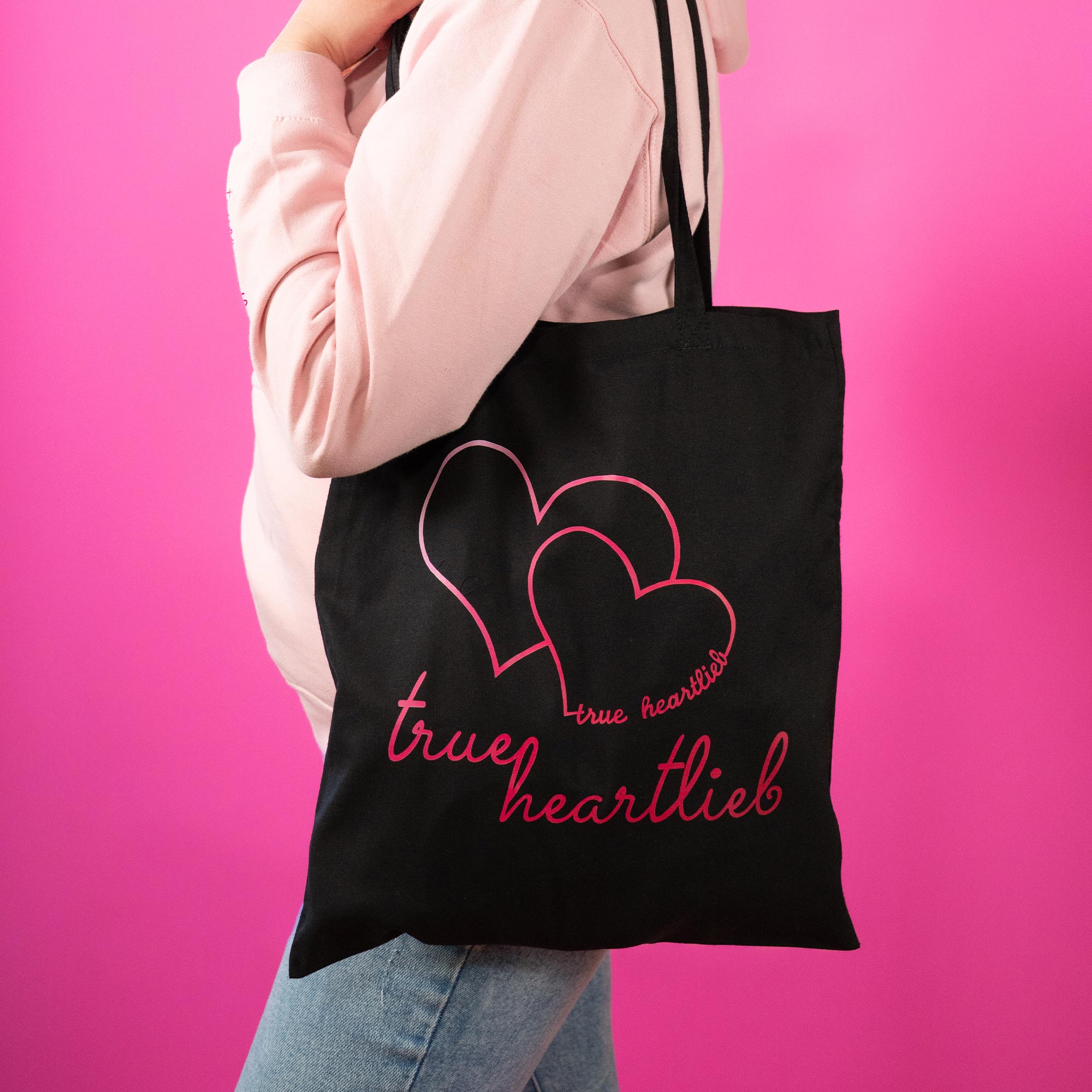 Frau trägt eine Trueheartlieb Tasche in Schwarz mit "Trueheartlieb" Motiv
